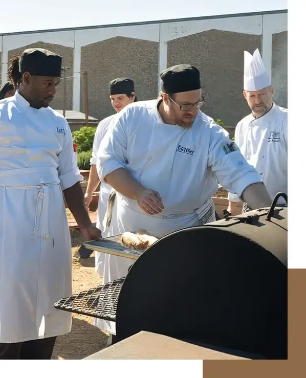 Escoffier Austin students barbecuing in an outdoor smoker