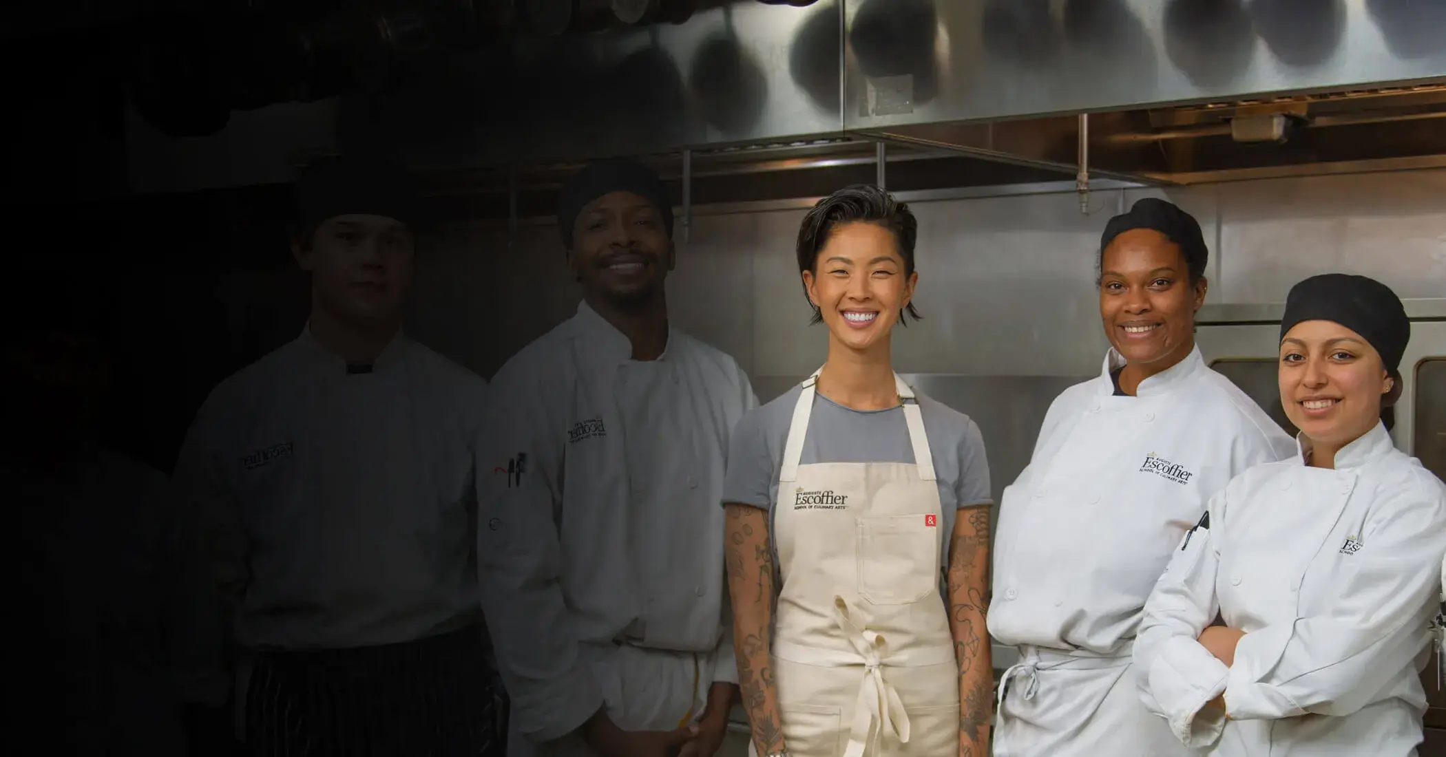 Kristen Kish stands with a diverse group of culinary students in an Escoffier kitchen