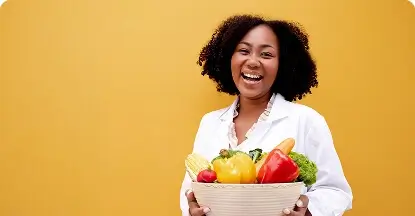 Happy nutritionist holding a basket of fresh vegetables against a yellow background