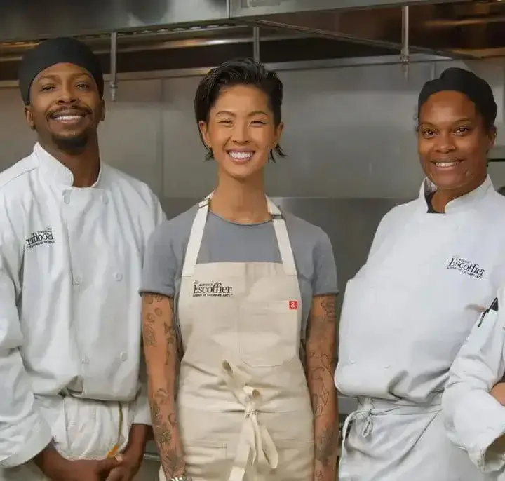 Kristen Kish stands with a diverse group of culinary students in an Escoffier kitchen