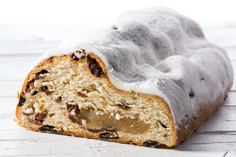 Sliced German stollen bread showing a marzipan filling in the center.