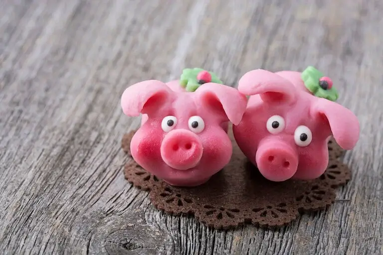 Two marzipan shaped and painted to resemble pigs.