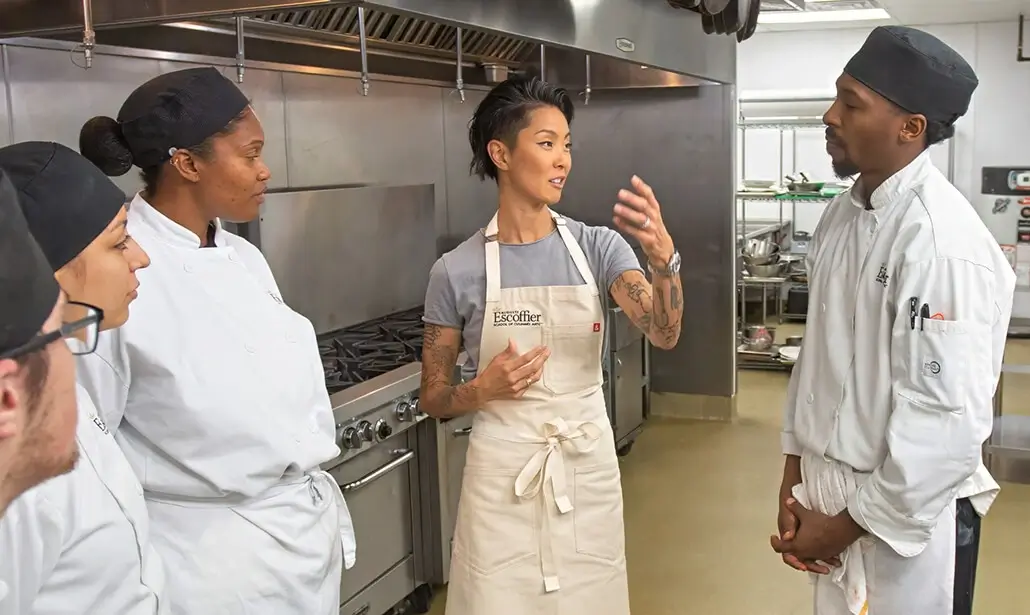 Escoffier chef-in-residence Kristen Kish speaks to Escoffier culinary students in a commercial kitchen on the Escoffier campus