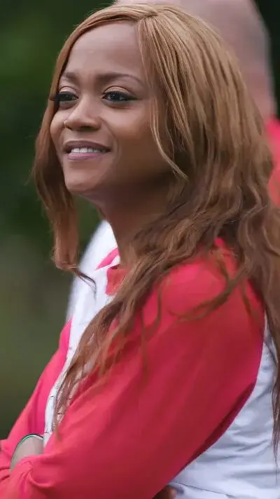 Smiling culinary student Tiffany Moore in red and white Escoffier shirt standing outdoors