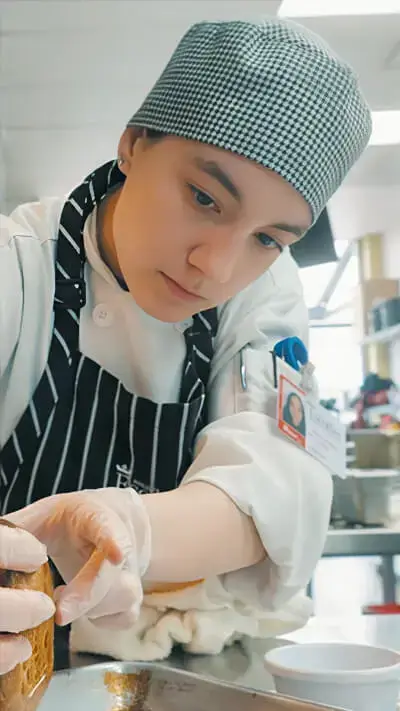 Focused culinary student Alana Leon Velez carefully prepares a dish at Escoffier.