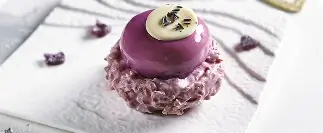 Purple glazed dessert with white chocolate disc and lavender