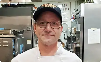 Blueberry chocolate tart with berry coulis splatter on a white plate