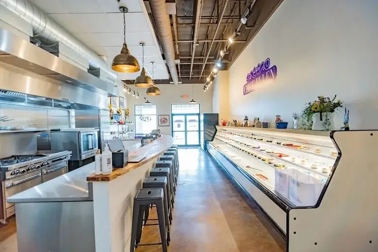 Interior of Chef Ellen's meal prep shop showing the 24-foot open cooler, commercial kitchen, and dining counter.