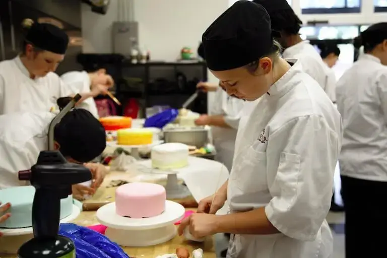 Culinary students working in a pastry kitchen.