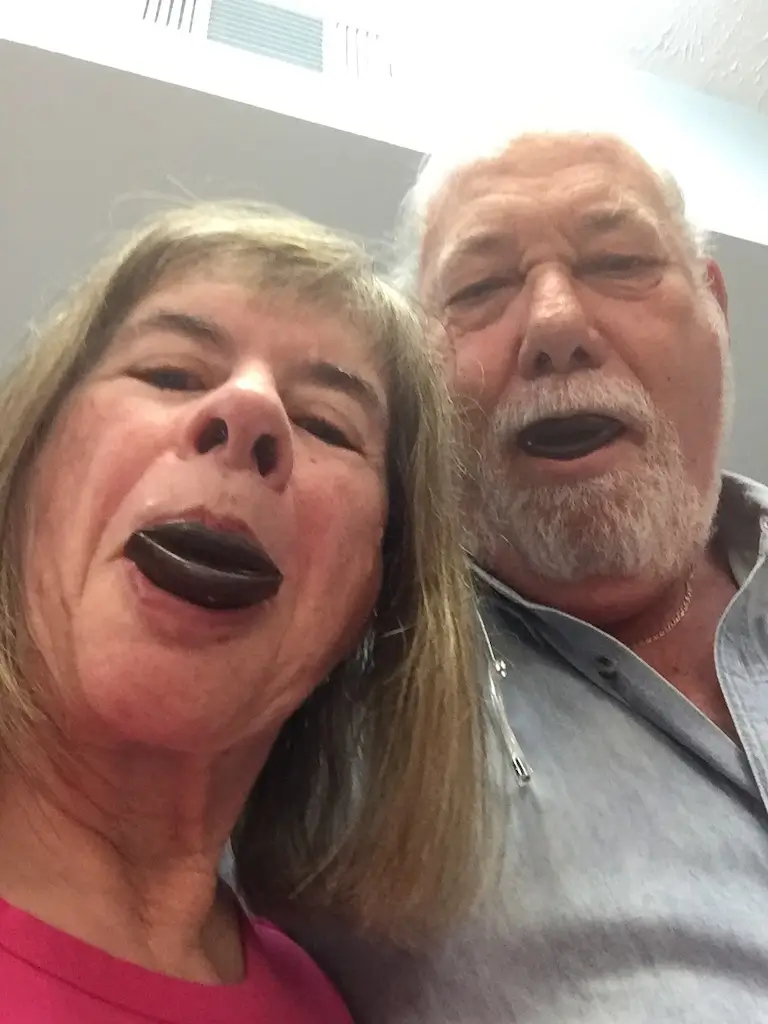 Two people enjoying chocolate made from a lip-shaped mold.