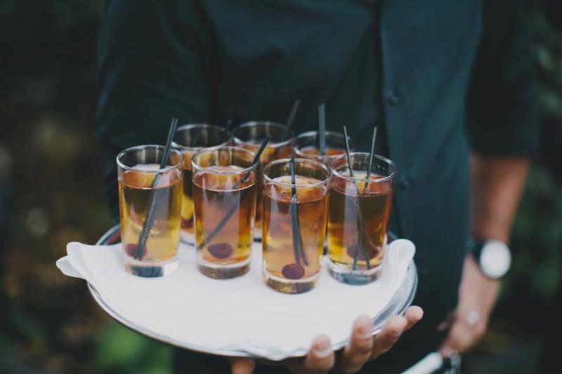 Plate of drinks held by waiter.