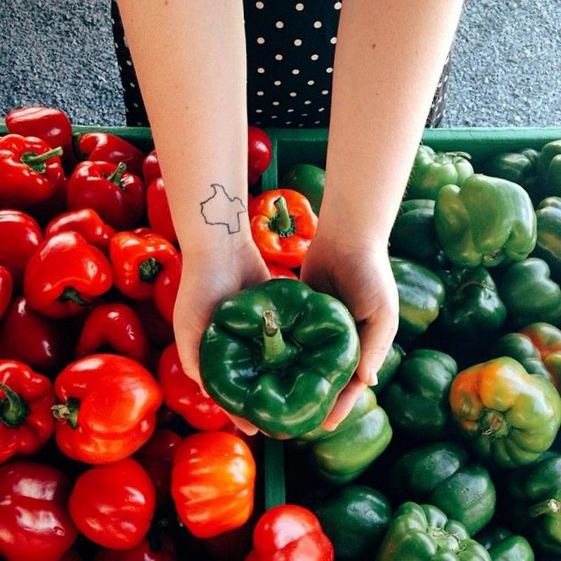 Woman picking peppers from baskets.