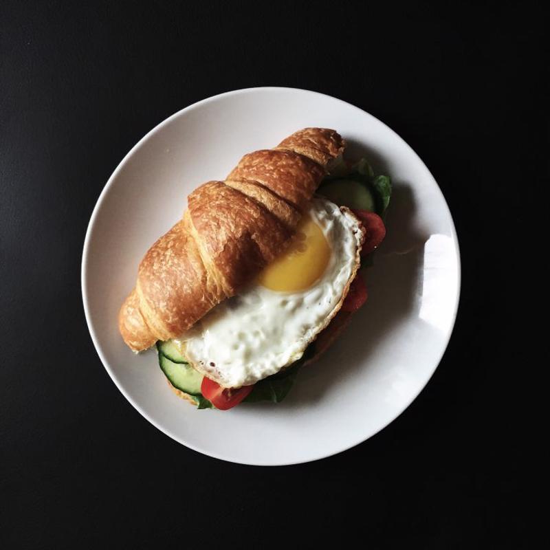 A croissant topped with a fried egg