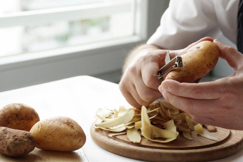 A man peeling potatoes.