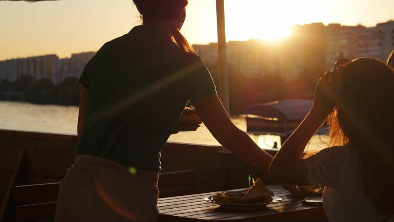 Waiter serving table on patio.