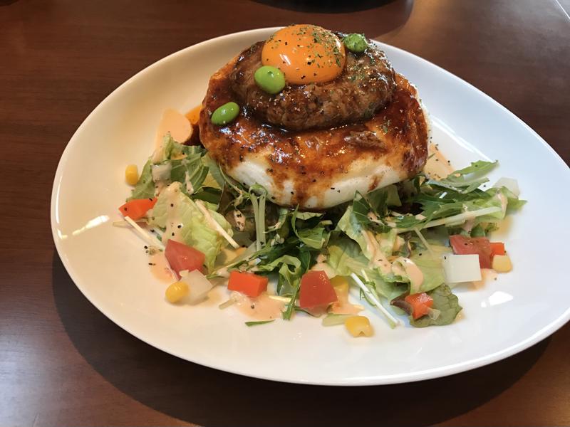 A close up shot of a plate holding a loco moco and salad.