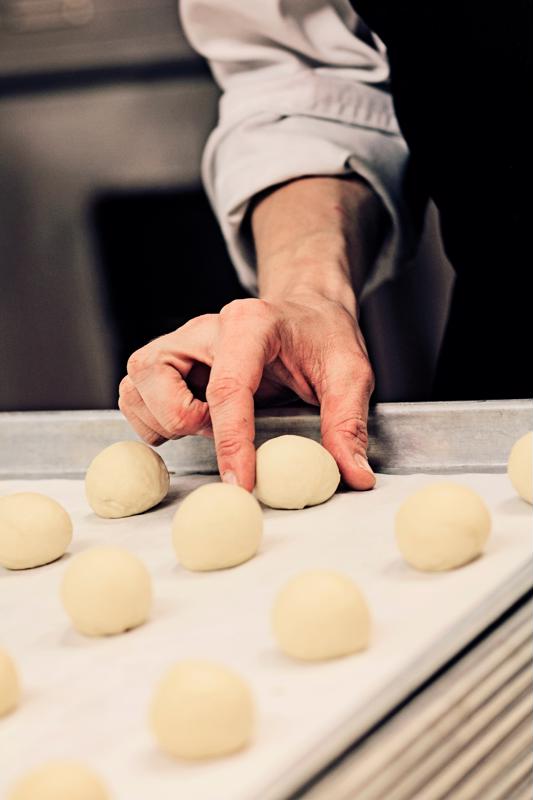 Baker setting dough on a sheet