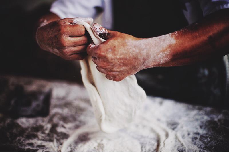 Close up shot of a chef kneading dough.