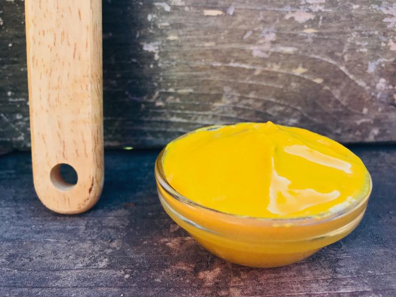 Yellow mustard in a glass dish.