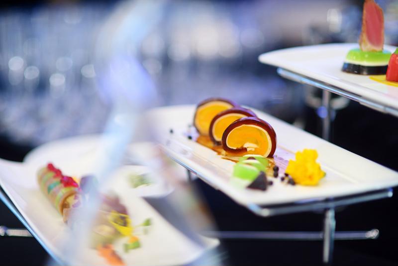 A closeup of a few rectangular plates of food.