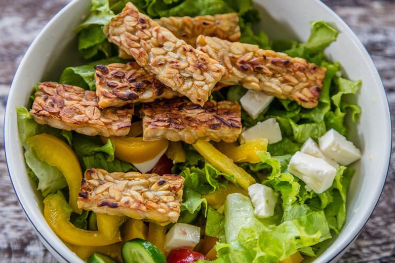 Tempeh over salad is a simple but effective way to prepare a probiotic-rich dish.