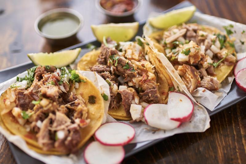 Three tacos sitting on plate.