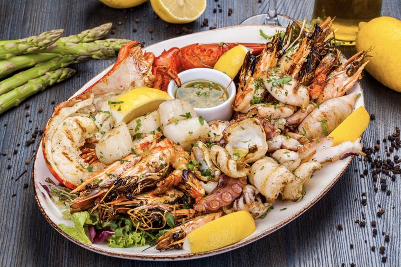 A mixed seafood plate served on a wooden table.